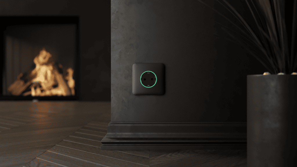 Nahaufnahme einer intelligenten Steckdose mit LED-Leuchte an einer schwarzen Wand.